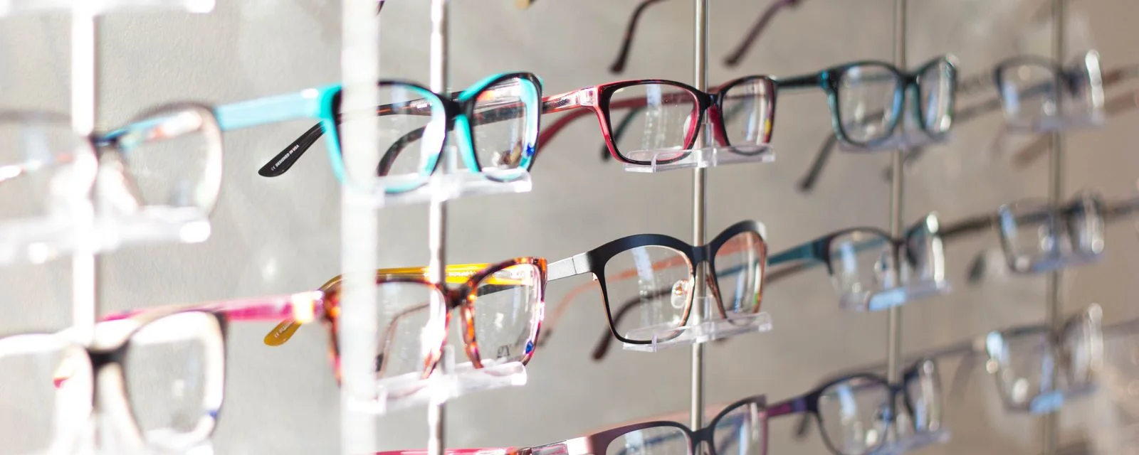 Rows of spectacle frames on a shop display wall